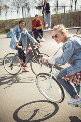 teenagers having fun and riding bicycles in skateboard park, bike riding city concept