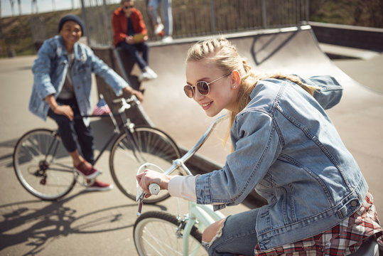 teenagers having fun and riding bicycles in skateboard park, bike riding city concept