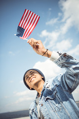 smiling african american teenager waving american flag, hipster style concept