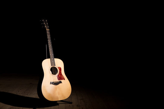 Acoustic guitar over dark background with copy space