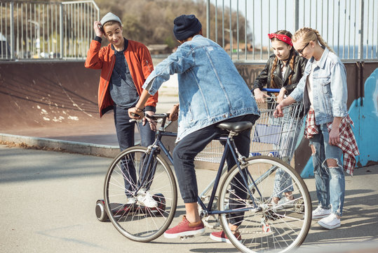 stylish teenagers spending time in skateboard park, hipster style concept
