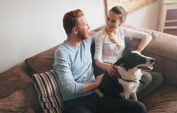 Beautiful Couple Relaxing At Home And Loving Their Dog