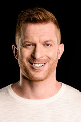 Fototapeta premium portrait of handsome redhead man smiling isolated on black