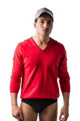 A young man with red wool sweater and underwear, wearing baseball cap, front view. Isolated on white background