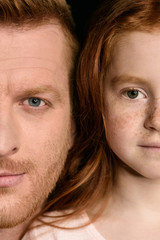 Cropped shot of beautiful redhead father and daughter looking at camera