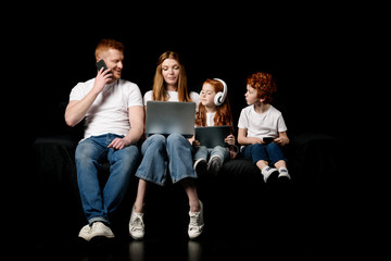 family using various digital devices isolated on black