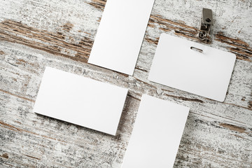 Photo of blank business cards and badge on vintage wooden table background. Blank template for placing your design.