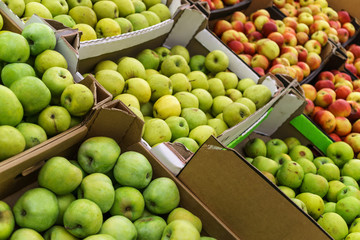 Boxes of green, yellow and red apples in the supermarket or on the market