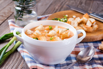 Homemade cream soup with croutons on wooden table