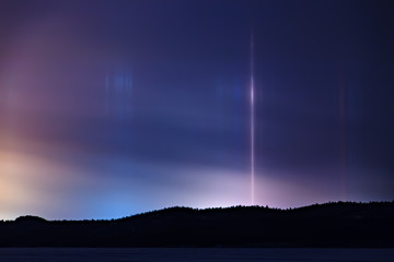 Light pillar hallo effect in atmosphere at night