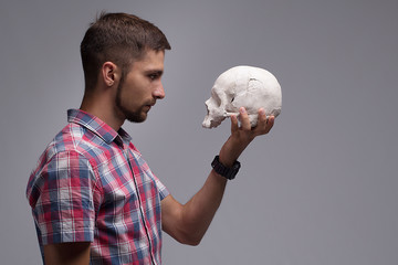 Portrait of a man in profile with a skull in his hand