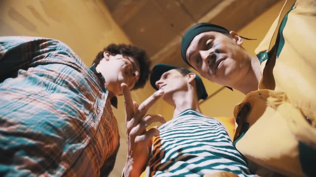 Three middle aged caucasian funny men dirty workers looking down into camera figuring something out, strats laughing