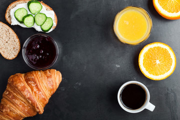 Brunch table with toasts, croissant, orange juice and coffee, top view