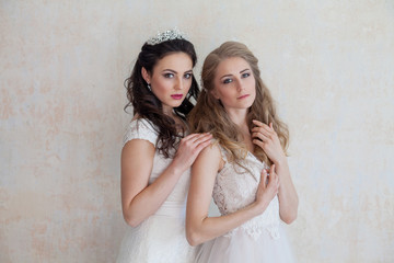 two girls in white dresses brunette and blonde