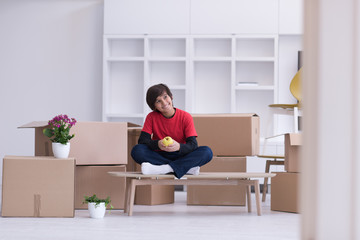 boy sitting on the table with cardboard boxes around him