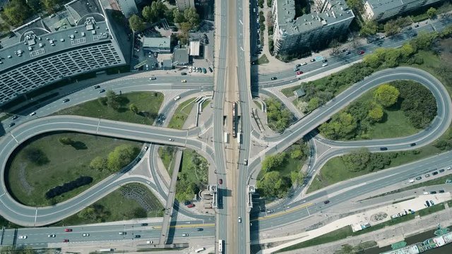 Aerial shot of big urban road junction on a sunny day, top down view. 4K video