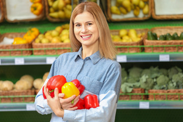 Beautiful woman buying vegetables in market