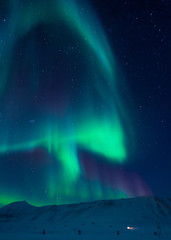 The polar Northern aurora borealis lights in Norway Svalbard in the mountains