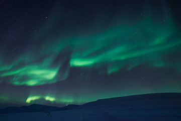 Fototapeta premium The polar Northern aurora borealis lights in Norway Svalbard in the mountains