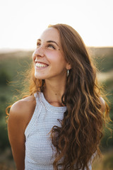 Smiling happy woman at sunset.