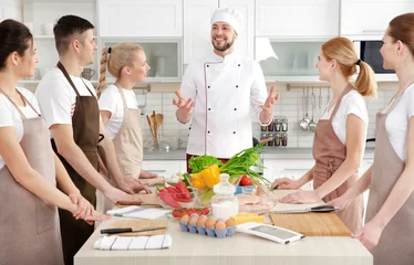 Fototapete Kochen Männlicher Koch und Gruppe von Personen bei Kochkursen