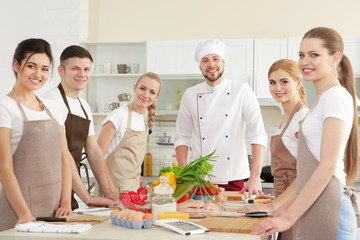 Chef masculin et groupe de personnes aux cours de cuisine