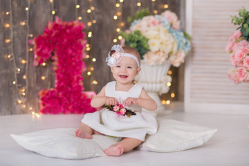 Fototapeta premium Cute baby girl 1-2 year old sitting on floor with pink balloons in room over white. Isolated. Birthday party. Celebration. Happy birthday baby, Little girl with group ball. Play room.