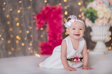 Cute baby girl 1-2 year old sitting on floor with pink balloons in room over white. Isolated. Birthday party. Celebration. Happy birthday baby, Little girl with group ball. Play room.