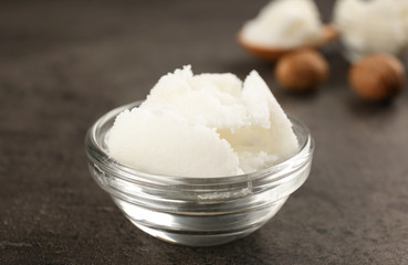 Shea butter in glass bowl on table, close up