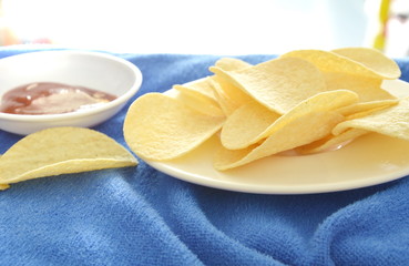 crispy and salt potato chips on dish dipping with tomato sauce