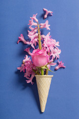 Flowers in a waffle cone on blue background