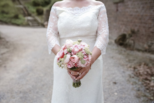 Midsection of bride holding bouquet