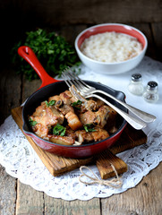 Fried pork belly in a cast-iron frying pan with onion, garlic and soy sauce.