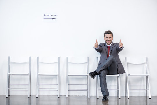 businessman showing thumbs up and waiting for interview in office, business concept