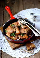 Fried pork belly in a cast-iron frying pan with onion, garlic and soy sauce.