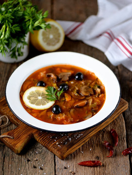 Traditional Russian soup solyanka made from cabbage, fresh and dried mushrooms with olives, lemon and capers.