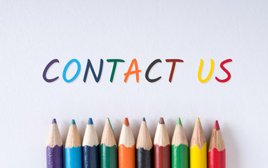 Text "Contact us" on white paper with color pencil on bottom center