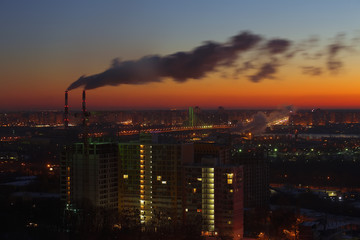 Fototapeta na wymiar Two industrial tubes, sunrise city view, pink warm sky.