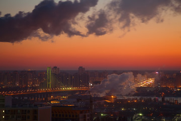 Fototapeta na wymiar Two industrial tubes, sunrise city view, pink warm sky.
