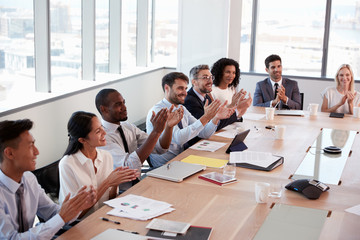 Businesspeople Around Boardroom Table Applaud Presentation
