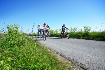 Naklejka premium Happy family riding bikes on week-end in countryside