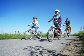 Fototapeta na wymiar Happy family riding bikes on week-end in countryside