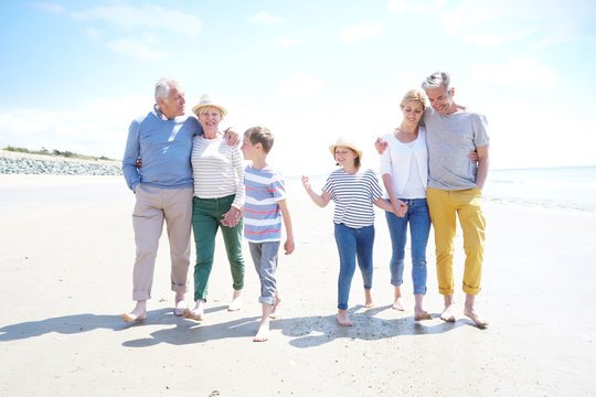 Family, Parents, Grandparents And Grandkids Walking On The Beach