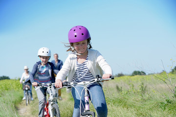 Obraz premium Happy family riding bikes on week-end in countryside