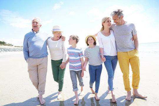 Happy intergenerational family walking on the beach