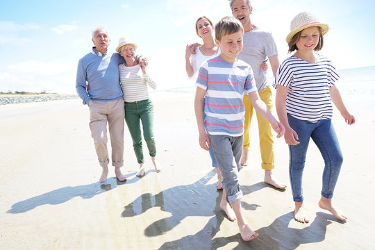 Happy intergenerational family walking on the beach