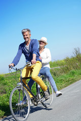 Cheerful couple riding bike on a sunny day
