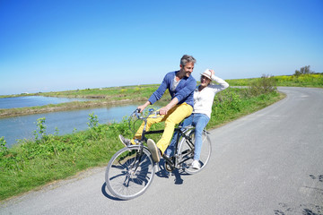 Fototapeta na wymiar Cheerful couple riding bike on a sunny day