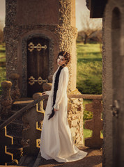 Young, beautiful girl in a nightgown. The princess walks by the castle. Creative colors