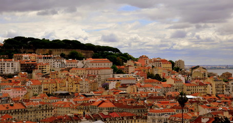 Blick auf die Dächer der Altstadt von Lissabon mit dem Meer im Hintergrund